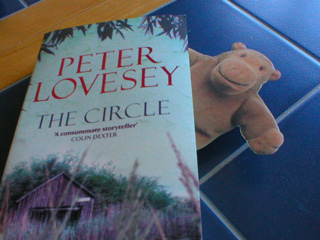A faux monkey peeping out from between the pages of a book