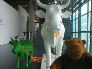 Mr Monkey with a large white cow and a small green cow, connected by flashing lights