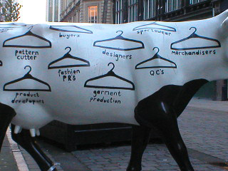 Detail of the cow, with a job title beneath each coat hanger