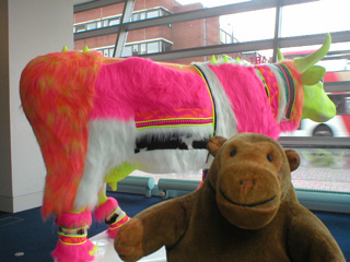 Mr Monkey beside a cow clad in flourescent furs