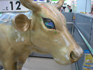 The head of a gold cow with sequins around its eye