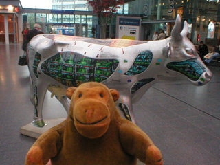 Mr Monkey with a silver cow with odd green patterned panels on its sides