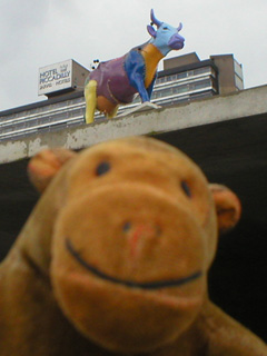 Mr Monkey below a patchwork, pin-stuck cow