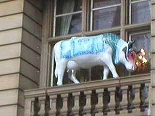Cow with a blue costume and red and purple eye shadow