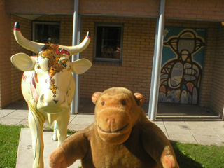 Mr Monkey with a pale cow in front of a painted door