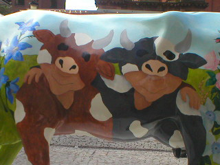 The side of a cow with two people dressed as cows