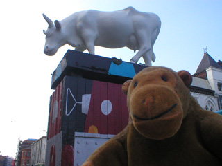 Mr Monkey with a plain white cow on a decorated pillar