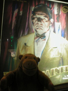 Mr Monkey looking at the poster outside the theatre