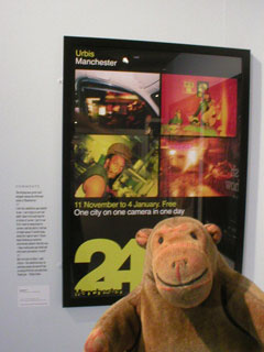 Mr Monkey looking at the Manchester 24 poster