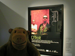 Mr Monkey looking at the DTroit exhibition poster