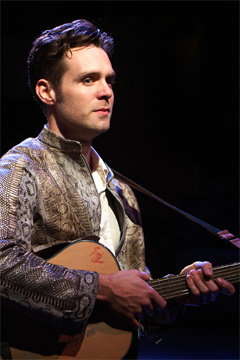 Val Xavier (Luke Norris) clutches his treasured guitar (Royal Exchange Theatre production photo)