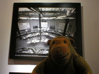 Mr Monkey looking at a photo of a surveillance camera control room