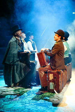 Phileas Fogg (Andrew Pollard) and Passepartout (Micheal Hugo) on the train from London to Dover (Royal Exchange Theatre production photo)