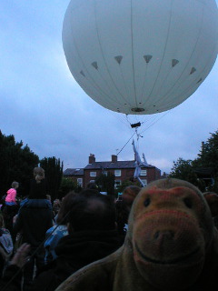 Mr Monkey watching the Moon acrobat descend to meet children in the crowd