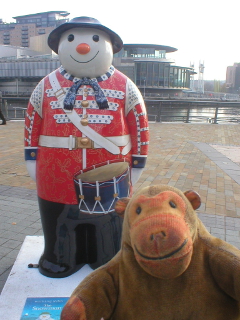 Mr Monkey looking at the Twelve Drummers Drumming snowman