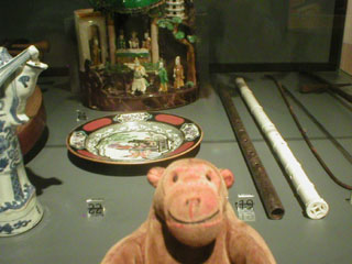 Mr Monkey looking at a model theatre and  a pair of flutes