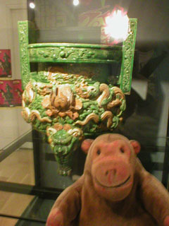 Mr Monkey examining an ornately decorated incense burner