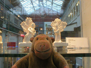 Mr Monkey looking at ceramic statuettes by Rose Wallace