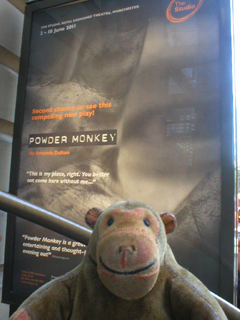 Mr Monkey looking at a poster for Powder Monkey