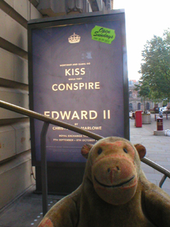 Mr Monkey looking at the Kiss Conspire poster outside the theatre