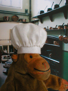 Mr Monkey wearing his chef's toque in a Victorian kitchen