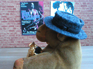 Mr Monkey in a pork pie hat, cradling a saxophone
