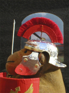 Mr Monkey wearing his Roman helmet and crest outside a gateway