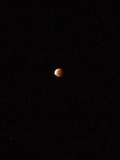 The moon at five past midnight, with a bright white edge to the red disc