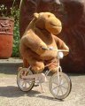 Mr Monkey cycles past garden pots
