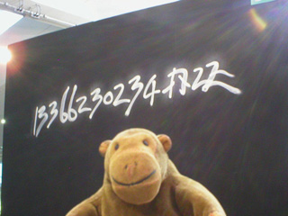 Mr Monkey being puzzled by a long number on a wall