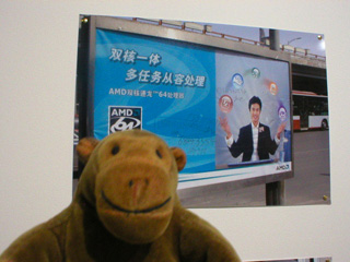 Mr Monkey in front of a picture of a poster with Ban Zheng numbers on it
