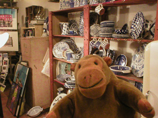 Mr Monkey examining plates and bowls at the Majolica Works