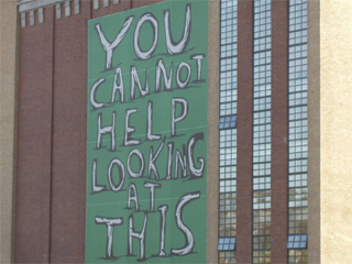 A banner reading 'You cannot help looking at this' on the side of BALTIC
