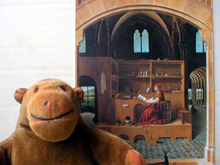 Mr Monkey in front of a postcard of Saint Jerome in his Study