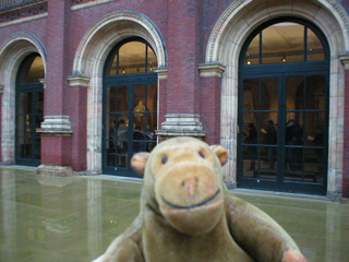 Mr Monkey looking at people queuing inside the V and A