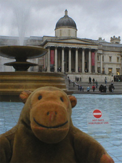 Mr Monkey looking at the National Gallery across a Trafalgar Square fountain