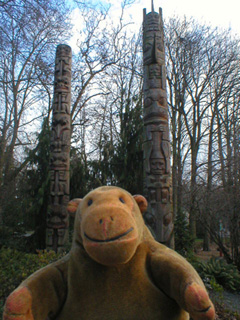 Mr Monkey looking at a pair of totem poles