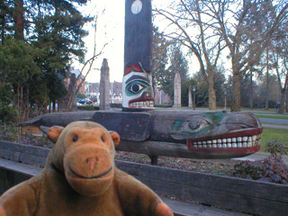 Mr Monkey looking at a killer whale totem