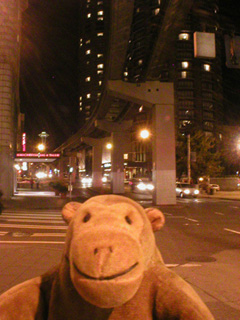 Mr Monkey walking under the monorail line to the Seattle Center