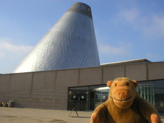 Mr Monkey looking at the outside of the Museum of Glass