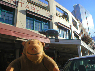 Mr Monkey looking at a painted pig on a porch