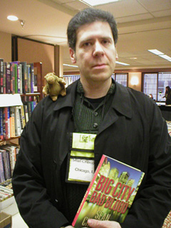 Sean Chercover holds his book with Mr Monkey on his shoulder