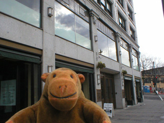 Mr Monkey looking at Smith Tower at street level