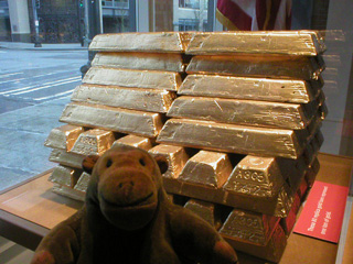 Mr Monkey examining a stack of gold bars