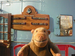 Mr Monkey looking at the battle honours of HMS Belfast