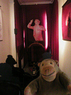 Mr Monkey looking at a cutout of Charles Dickens doing a public reading