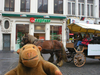Mr Monkey looking at a small brass band aboard a wagon