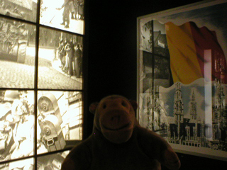Mr Monkey looking at pictures and posters from the end of World War Two