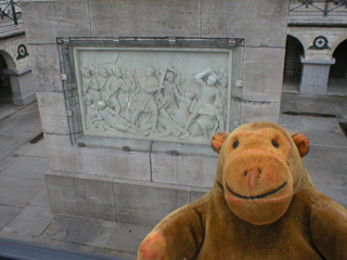 Mr Monkey looking at the carved reliefs at the base of the monument