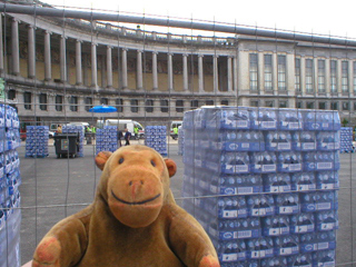 Mr Monkey looking at vast stacks of bottled water